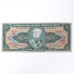 Numismática / Cédulas do Brasil. Cédula de 2 Cruzeiros (Cr$ 2,00), pertencente ao padrão monetário brasileiro do Cruzeiro, emissão do Tesouro Nacional. Estampa 2A, Série 740A, número de ordem 092713, impressa por Thomas De La Rue & Company Limited, Londres. Anverso com efígie de Luís Alves de Lima e Silva, Duque de Caxias, em medalhão central, ladeada pelo valor facial 2, inscrições República dos Estados Unidos do Brasil, Tesouro Nacional e Dois Cruzeiros  Valor Recebido, além das chancelas das autoridades monetárias. Reverso com representação da Escola Militar de Resende, atual Academia Militar das Agulhas Negras, ladeada por cartuchos com o valor facial. Impressão sobre papel fiduciário.