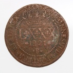 NUMISMÁTICA. Moedas do Brasil. Moeda de LXXX Réis, reinado de D. João VI, Reino Unido de Portugal, Brasil e Algarves, datada de 1821, cunhada em cobre, Casa da Moeda do Rio de Janeiro (R). Anverso com valor facial LXXX, data e letra monetária R, encimados por coroa real, circundados pela legenda "JOANNES VI D. G. PORT. BRAS. ET ALG. REX". Reverso com escudo coroado das Armas do Reino Unido de Portugal, Brasil e Algarves, circundado pela legenda "IN HOC SIGNO VINCES". Medida: Diam.: 40 mm.