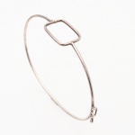 JOIA. Pulseira em metal prateado, de aro rígido e seção oval, constituída por fio contínuo com elemento central vazado de contorno quadrangular e cantos arredondados. Sistema de fechamento por gancho articulado, encaixado em elo triangular. Medidas: Comp.: 6,7 cm; Peso total: 5,5 gramasMedida: Diam.: 7 cm. ; Peso: 2.7 gramas.
