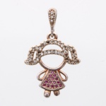 Pingente em prata com pedras incolores e espinélios sintéticos, de temática figurativa representando uma silhueta de menina, porção superior apresenta cravação de pedras incolores em lapidação brilhante que delimitam o cabelo, enquanto o vestido exibe preenchimento em pavé de tonalidade rosa-escura. O conjunto suspende-se por passador articulado igualmente ornado. O reverso exibe estrutura vazada com pátina de oxidação. Medidas: Comp.: 2,5 x Larg.: 2cm. ; Peso: 1.8 gramas.