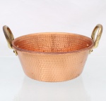 Tacho confeccionado em cobre martelado com alças em latão. Formato aproximadamente obcônico, bordo revirado e duas alças laterais arqueadas, fixadas ao recipiente por chapas e rebites de cobre. Interior com o mesmo tratamento martelado. Superfícies apresentando oxidação e marcas decorrentes do uso. Medidas: Alt.: 13,5 x Comp.: 25 x Larg.: 21 cm.