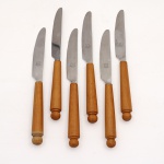 Conjunto de seis(06) facas de mesa, manufatura Hércules, confeccionadas em aço inoxidável, com lâminas de ponta arredondada e fio serrilhado, providas de cabos em madeira torneada, de perfil cilíndrico e terminação esférica. Lâminas com marca "HERCULES INOX" e logotipo da manufatura. Medidas: Comp.: 21,5 cm.