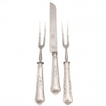 HERCULES INOX. Modelo Classique. Duas(02) garfos e uma(01) faca trinchante, para assados e aves, confeccionados em aço inoxidável, datável do período circa 1960-1970. Executados ao estilo francês do período Luís XV, apresentam cabos de perfil sinuoso e terminação espatulada, enriquecidos por ornamentação seriada em relevo que conjuga motivos de volutas, rocalhas e filetes perimetrais. Lâmina cega com ponta proeminente e sem corte. O reverso das hastes exibe a marca em baixo-relevo "HERCULES INOX" flanqueada pela especificação da liga metálica de alta resistência "18-8". Lâminas da faca exibe gume com acabamento serrilhado de fábrica e faces frontais com gravação em matriz ácida "Hercules AÇO INOX", integrada à efígie do fabricante sob o selo de têmpera especial "GELODUR". Medidas garfo: Comp.: 25,5 x Larg.: 3cm; Medidas faca: Comp.: 30 x Larg.: 3 cm.