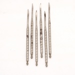 Conjunto de seis(06) utensílios para crustáceos em metal prateado. Constituídos por hastes fusiformes alongadas, com extremidade funcional estreita, achatada e recurvada, destinada à extração da carne de lagostas, lagostins, caranguejos e demais crustáceos. Empunhaduras cilíndricas revestidas por ornamentação helicoidal, alternando faixas lisas e campos de granulação circular, rematadas por terminais torneados em forma de botão. Superfícies com sinais de oxidação, desgaste e perdas localizadas do revestimento metálico. Medidas: Comp.: 12 cm.
