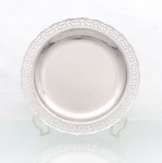 Bandeja circular em aço inoxidável 18/8, manufatura Meridional, formato circular de fundo liso e aba vazada, composta por sucessão de motivos geométricos e volutas estilizadas, com bordo recortado. Conserva etiqueta original da manufatura, com indicação "Aço Nobre Inox 18/8 / Stainless Steel 18/8", correspondente à liga de aço inoxidável com aproximadamente 18% de cromo e 8% de níquel. Apresenta marcas de uso. Medidas: Alt.: 3 x Diam.: 30 cm.