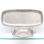 Conjunto de duas(02) peças para servir, confeccionadas em aço inoxidável. Composto por uma bandeja retangular de cantos arredondados, fundo liso e bordo elevado, e tigela circular de perfil canelado, com bordo ondulado. A bandeja apresenta no reverso marca gravada "Wolff INOX".  Medidas: Alt.: 2,5 x Comp.: 52 x Larg.: 22,5 cm; Medidas: Alt.: 4,5 x Diam.: 25 cm.