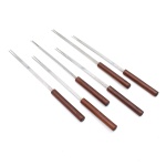 Conjunto de seis(06) pequenos garfos para petiscos, confeccionado em aço inoxidável e madeira, constituídos por hastes metálicas estreitas, terminadas em dois dentes alongados, destinados ao serviço de aperitivos, frios, queijos, azeitonas e pequenas porções. Cabos cilíndricos em madeira de tonalidade castanha, com acabamento liso. Medidas: Comp.: 27,5 cm.