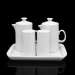 Galheteiro de mesa em porcelana branca. Conjunto composto por bandeja retangular, duas galhetas com tampas e par de saleiro e pimenteiro. Galhetas de corpo cilíndrico, bico vertedor integrado, alça em arco e tampas cônicas com puxadores; recipientes para condimentos identificados pelas letras perfuradas "P" e "S". Bandeja de formato retangular com cantos arredondados e bordo elevado. Conjunto destinado ao serviço de azeite, vinagre, sal e pimenta. Medidas: