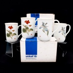 Conjunto de quatro(04) canecas em porcelana - UNICEF, fabricadas no Japão. Formato cilíndrico, com alças laterais e filete dourado no bordo, decoradas alternadamente com representações botânicas de gerânio e íris, acompanhadas de selos em caracteres orientais. No fundo, marca impressa "A World of Hope for Children - UNICEF - United Nations Childrens Fund - Made in Japan". Acondicionadas em caixas originais da UNICEF. Medidas: Alt.: 10 x Diam.: 7cm.