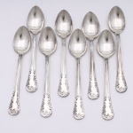 MERIDIONAL EPNS 100. Elegante conjunto de colheres médias confeccionadas em metal espessurado à prata(EPNS 100), cabo violinado com filetes longitudinais em baixo-relevo e terminação ornamentada por composição de concheados, volutas, flores e folhagens em relevo. Marca da manufatura puncionada no verso. Composto de oito(08) unidades. Medida: Comp.: 14cm.