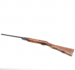 Antiga carabina de pressão, de atribuição provável à manufatura nacional Urko ou Caribe, circa 1960-1970. O modelo possui ação por mola com basculamento do cano e coronha inteiriça em madeira de lei com recortes recartilhados artesanais e zarelho inferior. Apresenta mecânica exposta com guarda-mato simplificado em chapa de aço e massa de mira cônica. Peça no estado de conservação em que se encontra, manifestando oxidação profunda e generalizada com pátina escura nos componentes ferrosos, além de escoriações e perda de verniz na madeira. Medidas: