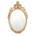 Espelho de parede decorativo com moldura oval em estilo Luís XV. Moldura confeccionada em madeira esculpida e vazada, recoberta por camada de gesso preparatório e pátina dourada. Apresenta frontão alteado composto por volutas confrontantes acopladas a uma grade central treliçada(rocaillie e gretado), ladeado por festões vazados de flores estilizadas com cinco pétalas que descem pelas laterais da moldura; porção inferior culmina em um botão de rosa ladeado por folhas simétricas. Espelho central de perfil oval ostenta acabamento bisotado(lapidação em bisotê). Verso revela o fechamento da chapa por placa de eucatex ou papelão rígido, provido de alça metálica para suspensão. Medidas: