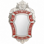 Excepcional espelho de parede decorativo em cristal veneziano, estilo Barão de Ladário, circa 1950. Apresenta formato recortado e silhueta sinuosa característica, estruturada com espelho central chanfrado em bisotê circundado por moldura perimetral em vidro de tonalidade rubi. Moldura exibe rica ornamentação executada em lapidação entalhada com motivos fitomórficos de ramagens, flores e gavinhas espiraladas, complementada por reservas lapidadas em pequenas semiesferas(olho de boi). Frontão alteado e a saia inferior são compostos por apliques sobrepostos de cristal incolor espelhado, recortados em formato de folhas e volutas acanaladas com gravações incisas florais e fixados por parafusos com ponteiras moldadas em formato de rosetas de vidro. Reverso estrutural, evidenciando chassi recortado em madeira para sustentação dos cristais frontais. Medidas: Alt.: x Comp.:(Este lote não poderá ser enviado pelos correios).