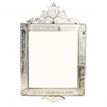 Belíssimo espelho de parede em cristal veneziano, circa 1950-1960. Formato retangular estruturado por espelho central plano com lapidação periférica em bisotê, moldura em placas de cristal incolor com ornamentação fitomórfica executada em lapidação entalhada e friso perimetral em semiesferas(olho de boi). Frontão em crista apresenta arranjo simétrico de apliques folheados, volutas e medalhão oval central com buquê floral, fixados por parafusos com ponteiras em rosetas facetadas de vidro, além de saia inferior recortada e acanalada. O reverso mantém o chassi estrutural recortado em madeira com fechamento central em placa de compensado. Medidas: Alt.: x Comp.: (Este lote não poderá ser enviado através dos correios).