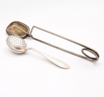 Dois(02) utensílios para chá em metal prateado. Composto por pinça para sachês de chá, de braços longos terminados em conchas ovais, destinada a retirar e comprimir o sachê após a infusão; e infusor de chá tipo colher, com receptáculo oval articulado, perfurado em ambas as faces, destinado a conter folhas de chá durante a infusão. O infusor apresenta cabo com decoração geométrica incisa e marca pouco legível. Ambas as peças apresentam sinais de uso e oxidação superficial. Medidas: