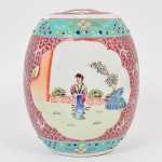 Pote com tampa para gengibre(ginger pot) executado em porcelana chinesa, formato similar a de um barril, dotado de rica decoração em esmalte policromado e relevado, ao gosto da família rosa, com duas reservas apresentando personagens em cena do cotidiano, fundo de tonalidade vermelha, realçada com motivo de flores e arabescos, tampa com alça iterna vazada. Marcado com ideograma ao fundo. Apresenta pequena quebradura na borda. Med.: Alt. 21 x Diam. 27 cm.