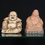 Duas(02) esculturas  em estuque, ambas representando personagem associado ao Budai/Maitreya, em postura sentada. Ambos com desgastes, um com quebradura na prate frontal. Meds.: 10 x 9 x 9 cm; 10,5 x 9 x 6 cm.