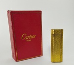 CARTIER: Isqueiro em plaque d'or da marca Cartier no estojo original. Med. 7 x 2,5 cm
