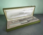 CHRISTOFLE PARIS : Excepcional conjunto de garfo e faca para trinchar em metal da maison Christofle France , padrão "Vinea" com relevos de folhas e uvas , no estojo original , nunca usado com o plastico protetor original , em perfeito estado . Med. 33 cm (faca) , 28 cm (garfo) e 37 x 15 cm (estojo)