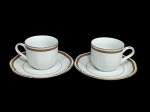 Requintado par de xícaras para café expresso longo, em porcelana branca da marca Laklain, fabricada por Dankotuwa, apresenta um filete com pintura à ouro duplo estampada com pequenos ornamentos geométricos repetidos, que remete à estética Art Déco.