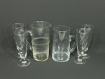 Lote com peças utilitárias de vidro, com: 1) Jarra com detalhe em frisos verticais - 11 cm d x 22 cm alt. 2) Jarra - 9 cm d x 19 cm alt. 3) 4 tulipas para choppe - 7 cm d x 19,5 cm alt.