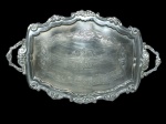 Bandeja em metal prateado com bordas trabalhadas em relevo, fundo cinzelado floral e linhas de contorno com arabescos - 53 cm x 39 cm.