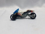 HOT WHEELS -  Hot Wheels Tri & Stop Me da série City Works de 2011. O veículo é um triciclo temático de `Beach Patrol` (Patrulha da Praia) com o número 3 estampado. É feito de metal fundido (diecast) e possui carenagem branca com detalhes em azul. Detalhes conforme fotos, _(ºLº)_ Caso necessite, tire todas suas dúvidas via atendimento personalizado por WhatsApp: (11) 98681-9377. Não deixe para última hora! Antecipadamente agradecemos pelo seu lance. Sem testes ou garantias futuras de originalidade, funcionalidade, material ou procedência.
