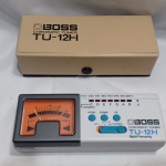 Afinador cromático BOSS TU-12H, apresentando um visor de ponteiro clássico para precisão. Inclui um estojo de proteção original na cor bege. O dispositivo possui um microfone condensador embutido e entradas de 1/4" para afinação de instrumentos acústicos e elétricos. Detalhes conforme fotos, _(ºLº)_ Caso necessite, tire todas suas dúvidas via atendimento personalizado por WhatsApp: (11) 98681-9377. Não deixe para última hora! Antecipadamente agradecemos pelo seu lance. Sem testes ou garantias futuras de originalidade, funcionalidade, material ou procedência.