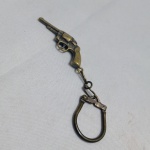 Chaveiro de metal no formato de um revólver, frequentemente descrito como um revólver .38. Possui acabamento metálico em tom de ouro velho. Detalhes conforme fotos, _(ºLº)_ Caso necessite, tire todas suas dúvidas via atendimento personalizado por WhatsApp: (11) 98681-9377. Não deixe para última hora! Antecipadamente agradecemos pelo seu lance.  (Similar: Espingarda, arma, garrucha, revolver, pistola, Rifle, Fuzil, Espingarda.). Sem testes ou garantias futuras de originalidade, funcionalidade, material ou procedência.