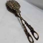 Antigo pegador de bolo feito em metal nobre intrincado estilo tesoura, com ornamentos detalhados com querubins e folhagens. Aprox. 21,5 cm. Detalhes conforme fotos, _(ºLº)_ Caso necessite, tire todas suas dúvidas via atendimento personalizado por WhatsApp: (11) 98681-9377. Não deixe para última hora! Antecipadamente agradecemos pelo seu lance. Sem testes ou garantias futuras de originalidade, funcionalidade, material ou procedência.