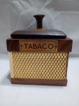 Antiga caixa de tabaco de madeira, possivelmente da década de 1950, apresentando um detalhe decorativo em trama metálica dourada. Possui pequeno quebrado no puxador e uma das bordas da parte da frente da caixa faltando. Aprox. 9,5 x 12 x 12cm. Detalhes conforme fotos, _(ºLº)_ Caso necessite, tire todas suas dúvidas via atendimento personalizado por WhatsApp: (11) 98681-9377. Não deixe para última hora! Antecipadamente agradecemos pelo seu lance. Sem testes ou garantias futuras de originalidade, material, legitimidade ou procedência.