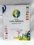 FUTEBOL - Livro ilustrado oficial (álbum de figurinhas) da CONMEBOL Copa América Brasil 2019, produzido pela editora Panini. Incompleto. Detalhes conforme fotos, _(ºLº)_ Caso necessite, tire todas suas dúvidas via atendimento personalizado por WhatsApp: (11) 98681-9377. Não deixe para última hora! Antecipadamente agradecemos pelo seu lance. Sem testes ou garantias futuras de originalidade, funcionalidade, material ou procedência.