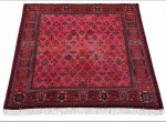 Tapete persa ISFAHAN, figuras policromadas sobre fundo vermelho com proteção de couro nas laterais e franja. Mede 2,15 x 2,10cm.