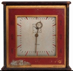 Relógio de mesa ELEXA, caixa metálica com mostrador quadrado e detalhes em tons de vermelho e dourado, fabricação Made in USA, apresentando marcas naturais do tempo e desgaste compatíveis com a idade. No estado. Medidas: 15 x 15 cm.