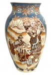 Vaso japonês em faiança estilo Satsuma, decoração policromada e dourada em relevo, apresentando cenas com personagens orientais em paisagem, reservadas sobre fundo azul com motivos florais. Peça ricamente esmaltada, típica da produção de exportação do início do século XX, em bom estado de conservação. Mede 30cm de altura.