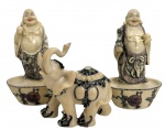 Trio de esculturas orientais decorativas, representando dois Budas da Fortuna sobre bases e um elefante ricamente ornamentado. Produzidas em resina imitando marfim, com detalhes policromados, de inspiração oriental. Conjunto em bom estado de conservação, ideal para decoração ou coleção. Medida do maior 13cm.