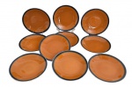 Conjunto com 10 pratos para sobremesa em porcelana Oxford, na tonalidade terracota com borda azul-escura esmaltada. Pintados a mão. Marca na base. Medida: 18 cm de diâmetro. Em bom estado de conservação, conforme fotografias. Um contém bicado.