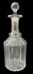 Garrafa licoreira em cristal translúcido, corpo sextavado com lapidação vertical, gargalo alongado e tampa original lapidada. Tampa com discreto bicado no interior. Medidas: 30 cm de altura.