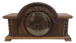 Relógio de mesa SILCO, em caixa de madeira entalhada, mostrador com numerais romanos, porta frontal envidraçada e mecanismo mecânico de corda com carrilhão. Acompanha chave. Em bom estado de conservação. Funcionamento desconhecido. Medidas: 51  30 cm.