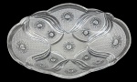 Centro de mesa em denso cristal translúcido prensado, formato oval recortado com bordas onduladas e rica decoração em alto-relevo com motivos geométricos e estrelas. Peça elegante para composição de mesa ou decoração. Medidas: 35 x 22 cm.