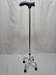 Bengala de alumínio com quatro pontas, altura ajustável e cabo ergonômico em polímero preto. Medindo 70cm de altura mínimo x 94cm de altura máximo.