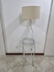 Mesa de canto com abajur acoplado em metal branco, tampo em vidro incolor e cúpula em tecido. Medindo 36cm de diâmetro x 70cm de altura da mesa x 130cm de altura total. Este lote não pode ser enviado pelo Correios. Funcionando.