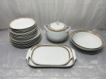 Steatita - Jogo de jantar com 23 peças em porcelana com borda ouro decorada. Medindo os pratos sobremesa 19cm de diâmetro, sopa 21,5cm de diâmetro, mesa 25cm de diâmetro, travessa G 30cm x 19cm, travessa P 26cm x 17,5cm, sopeira 14,5cm x 12,5cm de altura, travessa redonda G 24,5cm x 7cm de altura e travessa redonda P 22cm x 6cm de altura. Desgaste no friso.