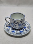 Xícara de café em porcelana portuguesa com flores azuis, assinado Outeiro Águeda. Medindo a xícara 6,5cm x 6cm de altura e o pires 12cm de diâmetro.