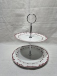 Porta confeito com 2 andares em porcelana com flores vermelhas. Medindo o prato maior 20,5cm e o menor 17cm x 24cm de altura total.