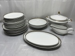 Jogo de jantar completo para 6 pessoas em porcelana Steatita com borda grega. Composto de18 pratos, 2 travessas ovais, 2 travessas redondas, sopeira e molheira. Medindo os pratos sobremesa 19cm de diâmetro, mesa 24,5cm de diâmetro, sopa 21,5cm de diâmetro; travessas redonda grande 24,5cm x 6,5cm de altura, redonda pequena 22,5cm x 6cm de altura, oval pequena 28,5cm x 18cm, oval grande 32,5cm x 20cm; sopeira 18,5cm x 11cm de altura, molheira 16cm x 9cm x 7cm de altura.
