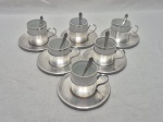 Jogo de 6 xícaras de café em porcelana com suporte, pires e colheres em prata 90. Medindo 5cm x 5cm de altura. Com leves desgastes.