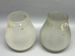 Par de antigas cúpulas em demi cristal satinê jateado, formato bulboso com corpo liso e sutil estreitamento em direção à extremidade superior. Medidas: 14x8,5x6,5 cm. Apresentam marcas do tempo, de uso, resíduos, manchas escuras e desgastes na borda de encaixe.