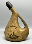 DIVERSOS - Antiga garrafa ou cantil em cerâmica esmaltada com efeito salpicado, corpo assimétrico com alça lateral integrada e gargalo inclinado arrematado por vedação original encerada. Apresenta decoração esgrafiada e pintada em preto na fachada retratando uma embarcação à vela navegando sobre ondas. Medindo 25 cm de altura, com desgastes naturais do tempo e marcas de uso.