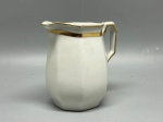 PORCELANA FRANCESA - Antiga jarra de porcelana Limoges (alt. 10 cm), com marca de fabricação B&C (Bernardaud & Co.) na base, corpo facetado em formato octogonal, alça geométrica e elegante faixa superior dourada na borda.